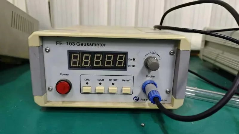 Handheld measuring instrument connected to a probe on a test bench during a functional check