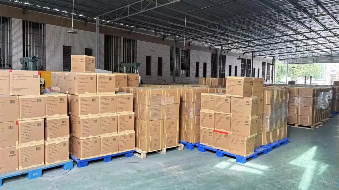 Palletised cartons on the floor of a dispatch bay under a steel roof structure